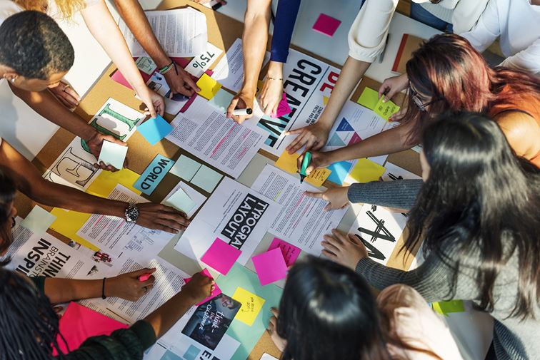 group of people gathered around a table to work on group project