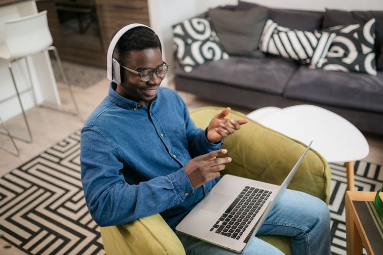 person wearing headphones and using the laptop