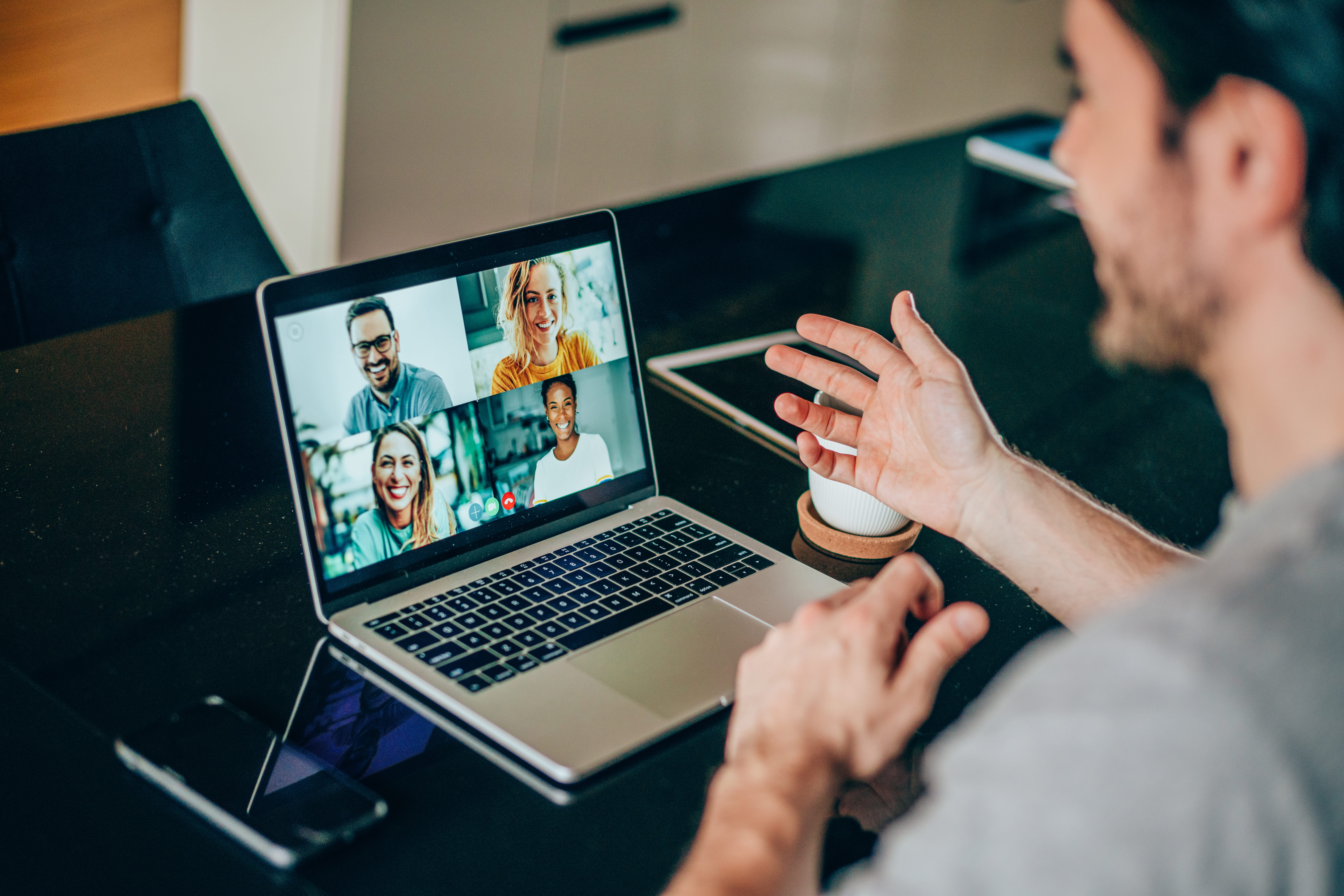 Man looking at laptop and talking on video conference