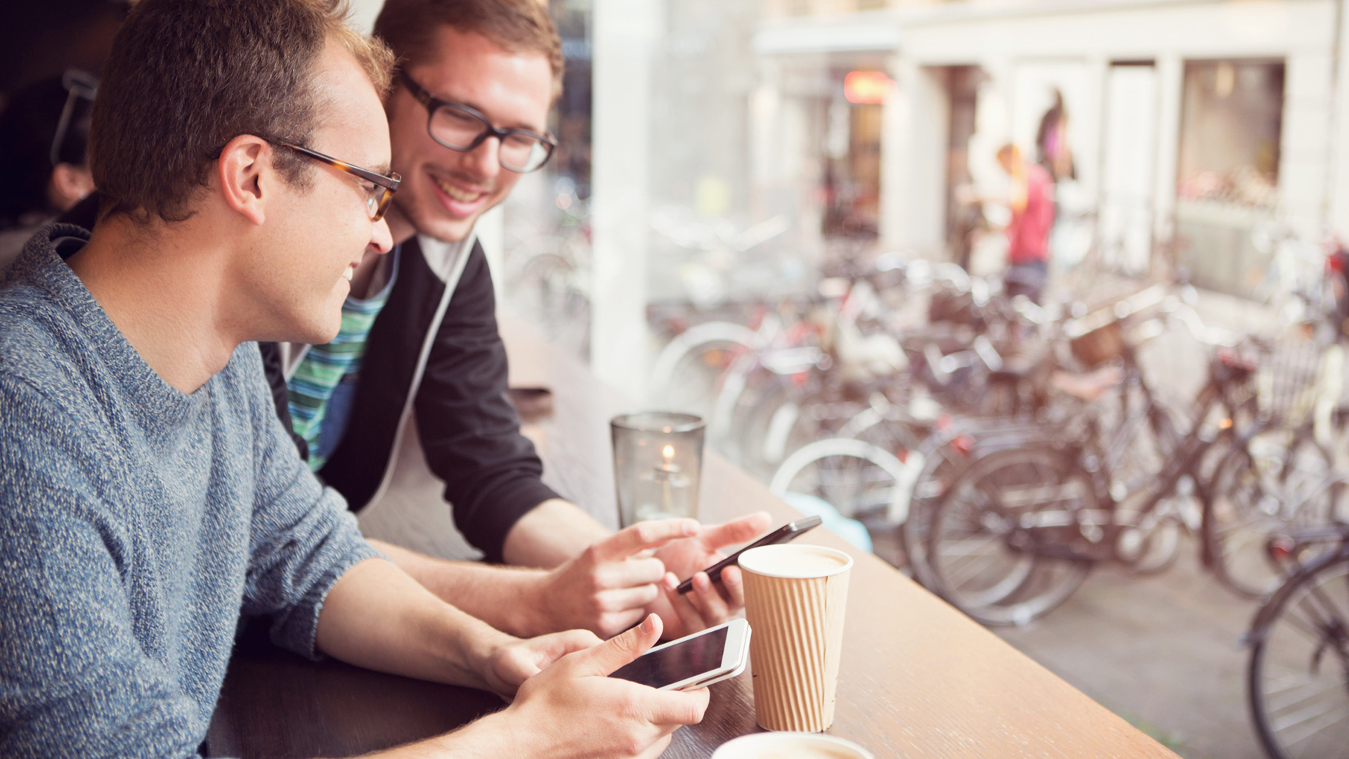 Young men with glasses discussing superannuation plans in cafe