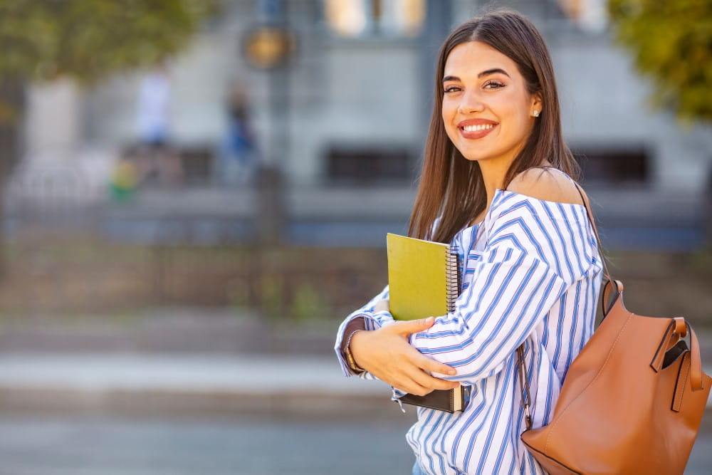Photo of young woman holding books
