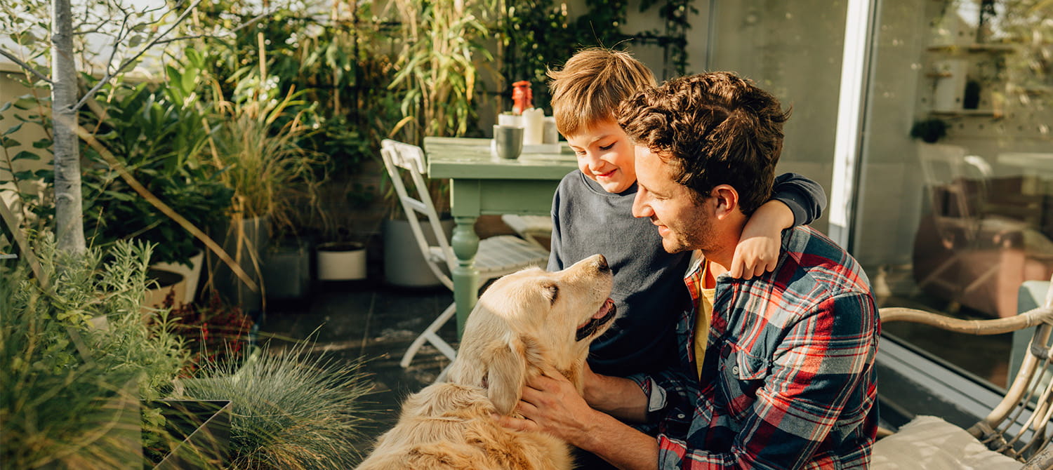 Man and boy on a deck with a dog