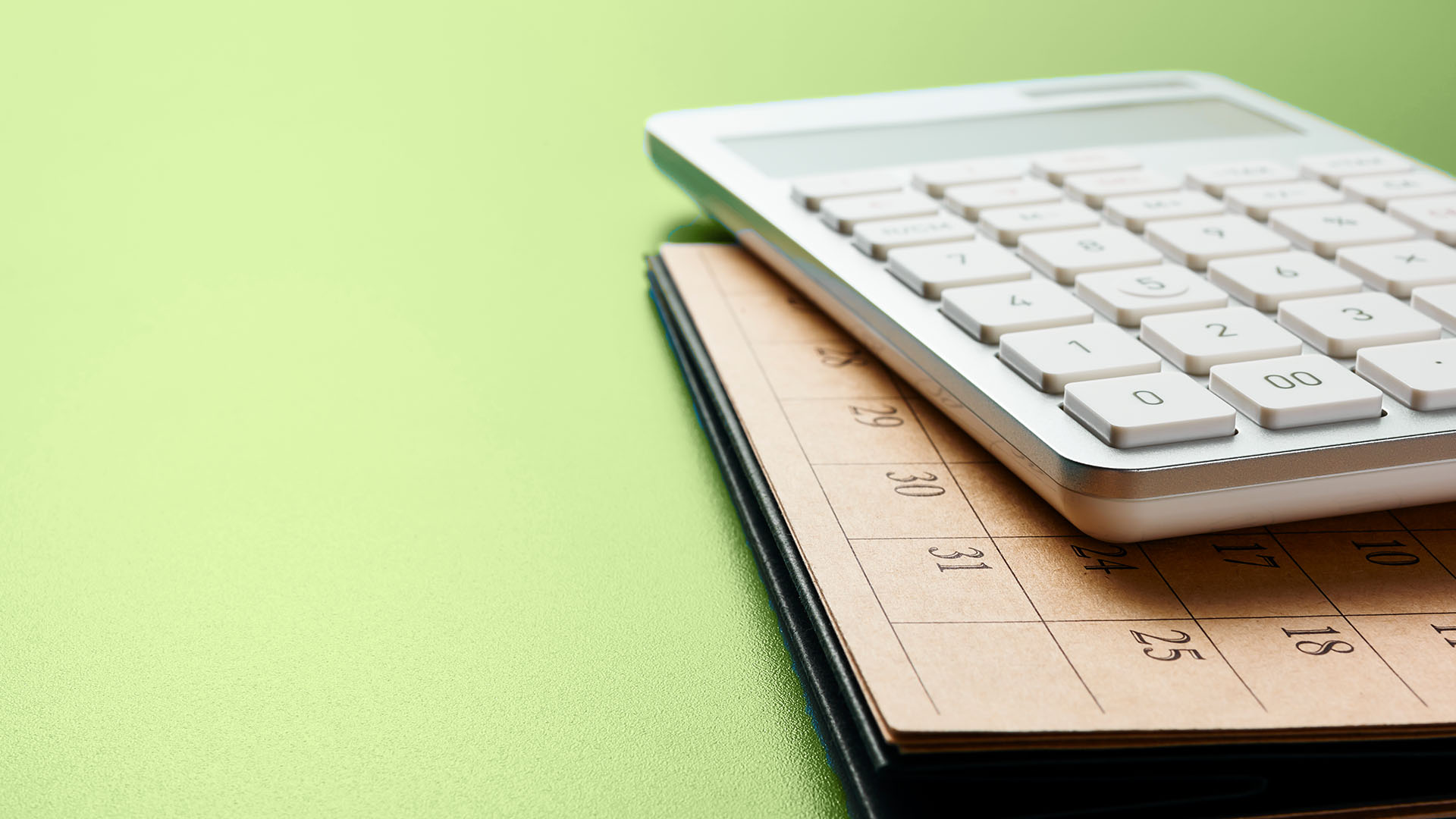 Calculator resting on a folder showing dates