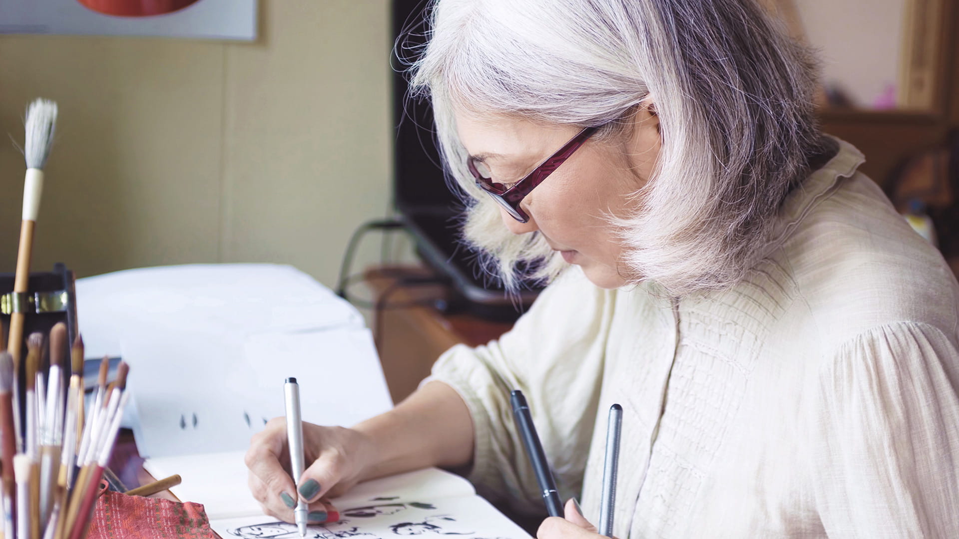 Elder woman with glasses painting