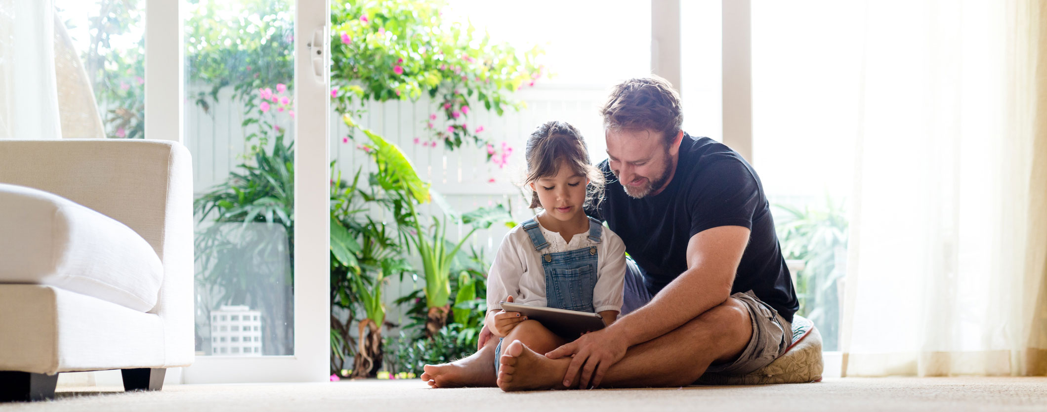 Father and daughter looking at a tablet together
