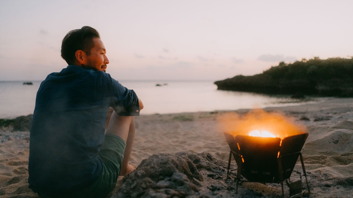 Man at the camp fire on the beach