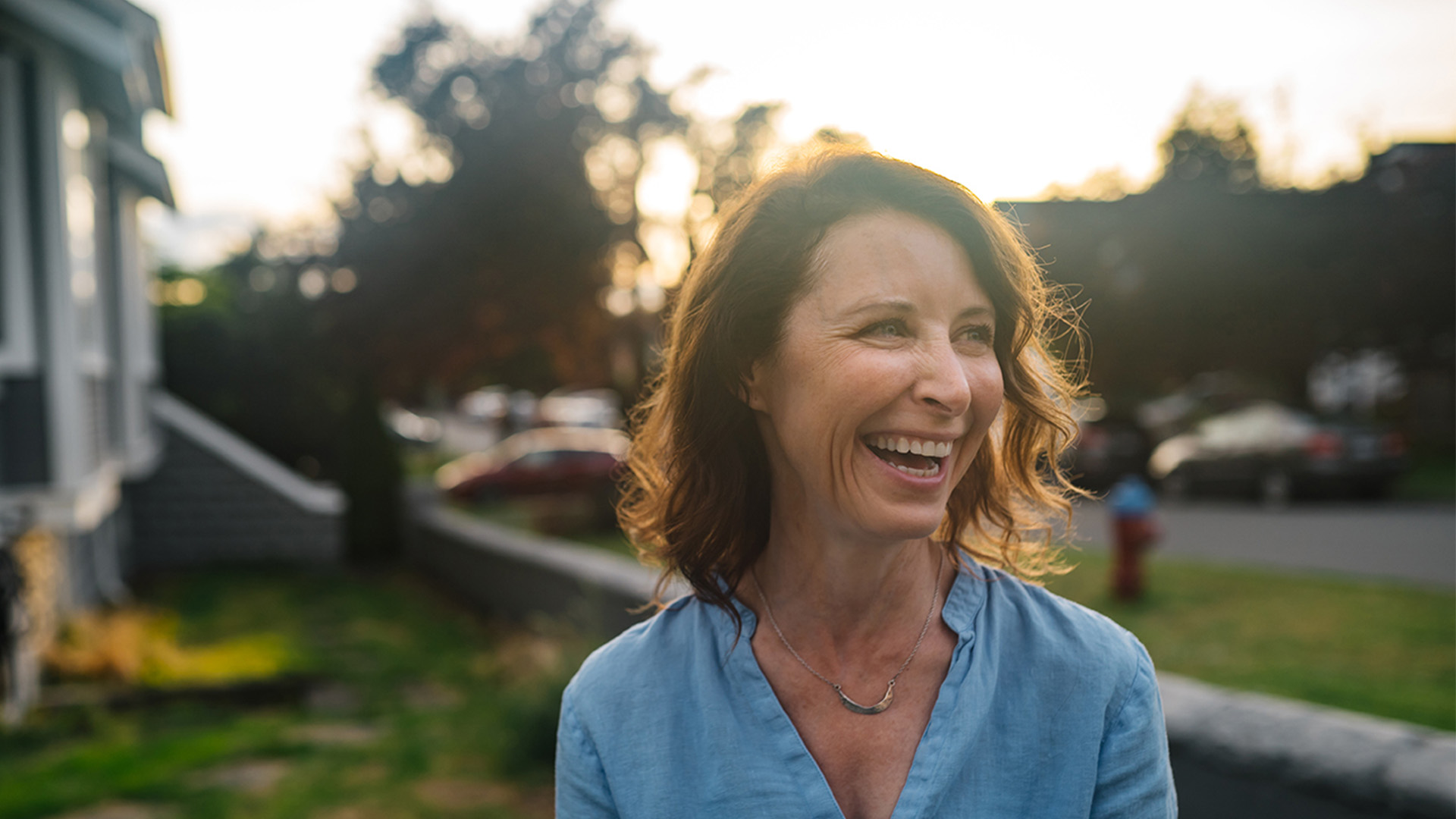 Woman standing in her backyard smiling