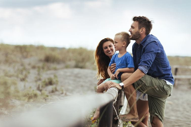 Young parents relaxing with their son in the nature at summer