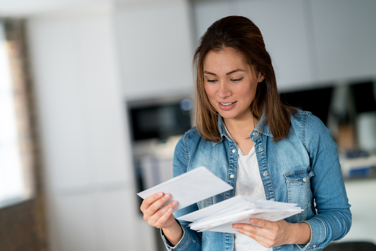 Woman holding and opening her mail